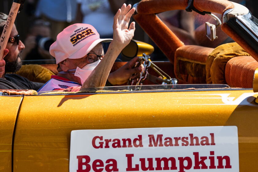 Bea Lumpkin, 104, this year's grand marshal of Chicago's Labor Day Parade, salutes Saturday as she rides south on Ewing Avenue in the East Side neighborhood.