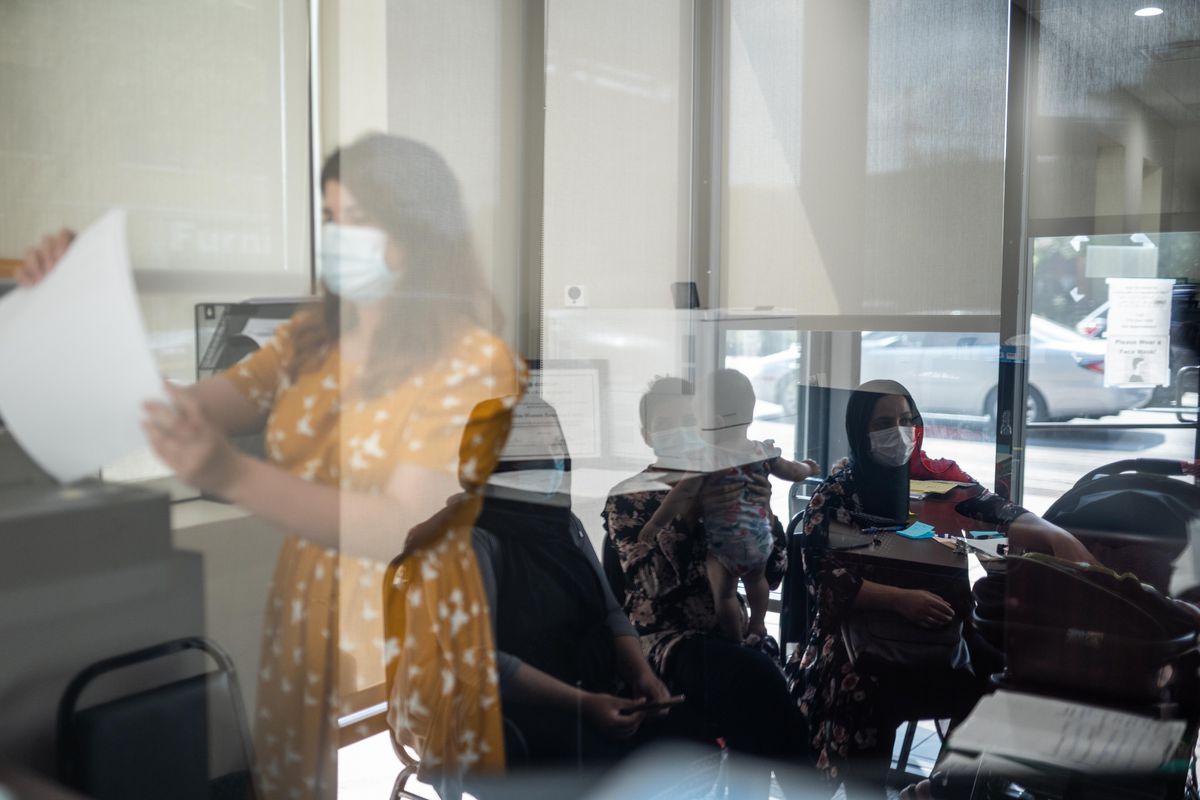 Alina Hanif, a social worker at the Muslim Women Resource Center in the West Ridge community, works while Afghan Americans wait for their social worker to advise them on the steps to take to bring their families to the United States.