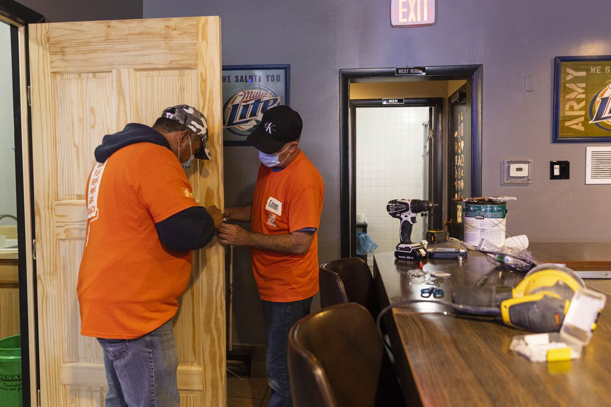 Home Depot workers Jose Murillo, left, and Luis Bacallao, right, install a door to the VFW kitchen on Thursday, November 11, 2021, at VFW Post 3940 at 3743 W 63rd St in West Lawn.